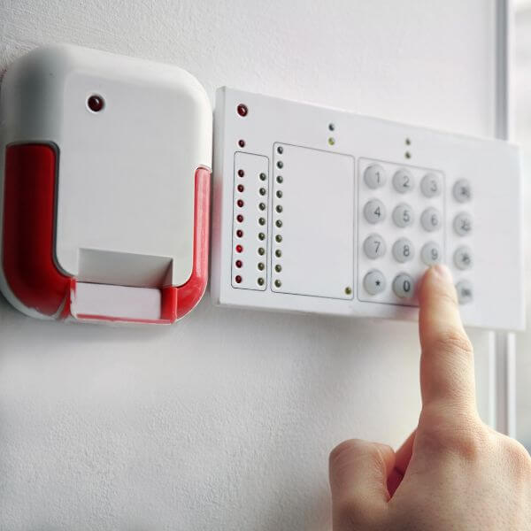 Home Security Guys completing home security alarm system installation in Brisbane, featuring a wall-mounted keypad and internal siren unit.