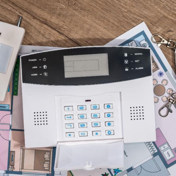 Home Security Guys preparing for home security alarm system repairs in Brisbane, showing control panel and system layout.
