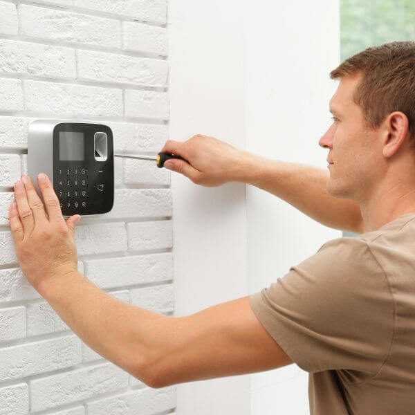Home Security Guys performing home security alarm system installation in Sydney with keypad mounted on interior wall.